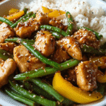 Honey sesame chicken stir fry in skillet with vegetables