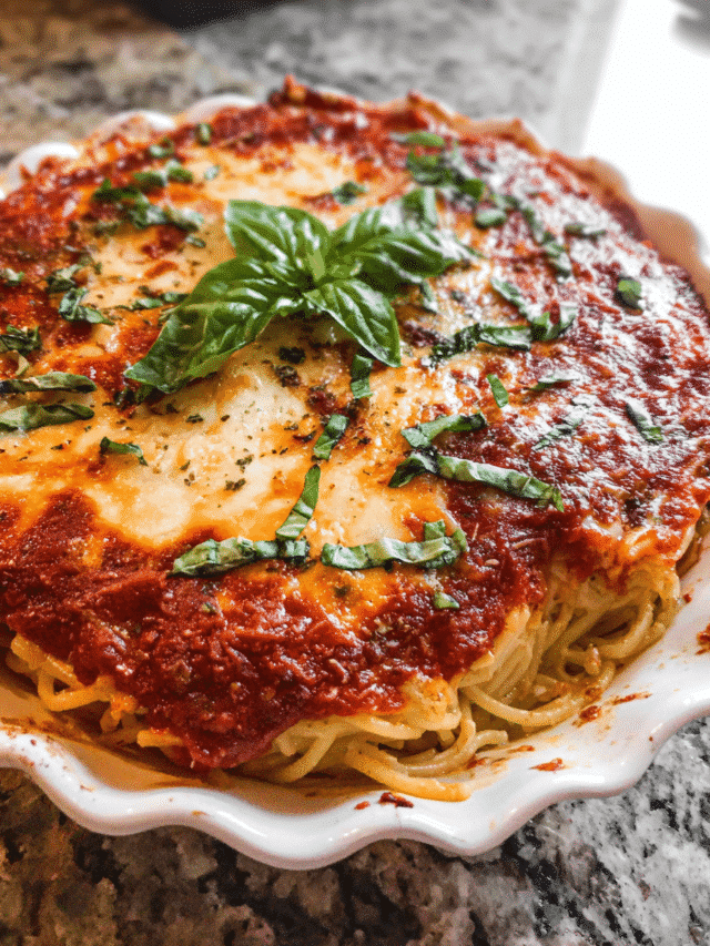 Spaghetti Pie baked in a dish with marinara and ricotta layers