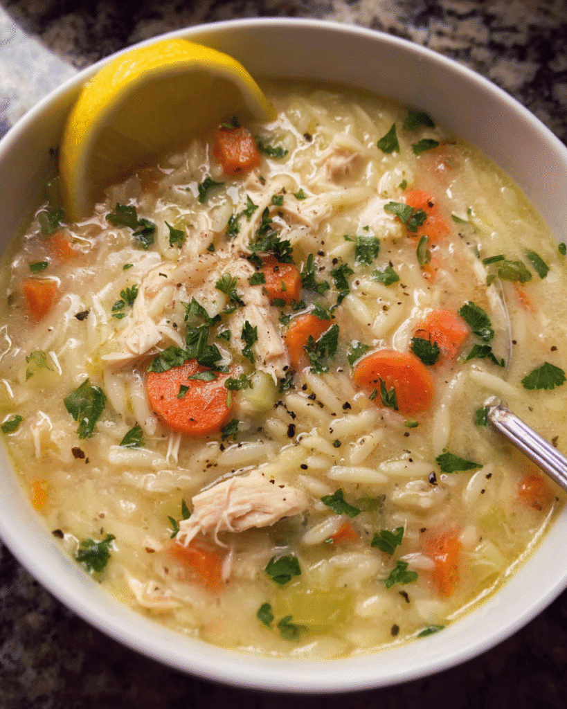 Lemon Chicken Wild Rice Soup in a bowl with lemon zest and greens