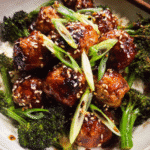 Honey garlic meatballs in a skillet with broccoli and glossy sauce