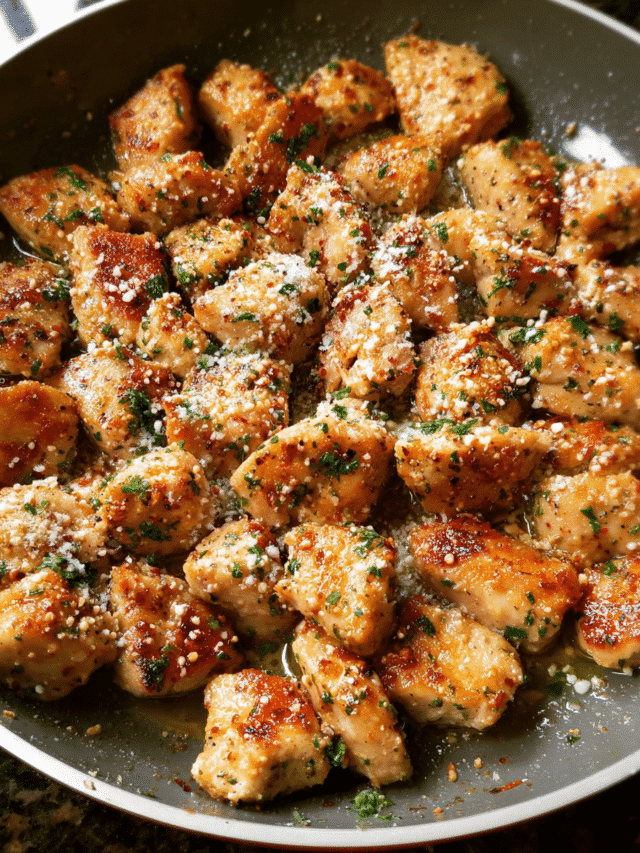 Garlic Parmesan Chicken Bites in a skillet coated with butter and Parmesan