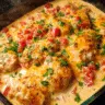 Baked queso chicken in casserole dish topped with melted cheese