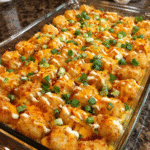 Buffalo chicken ranch casserole with crispy tater tots and melted cheese in a baking dish