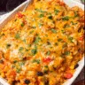 Cheesy chicken taco casserole baked with melted cheese and crushed tortilla chips in a white casserole dish