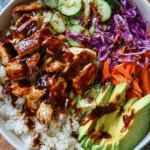 Creamy BBQ chicken rice bowl with avocado, cabbage, and BBQ sauce