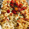 Creamy Chicken Enchilada Pasta Bake in a casserole dish with melted cheese and fresh toppings
