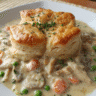 Creamy Garlic Chicken Biscuit Bake in a white baking dish with golden brown biscuits on top.