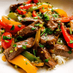 Pepper steak stir fry with colorful bell peppers in a skillet