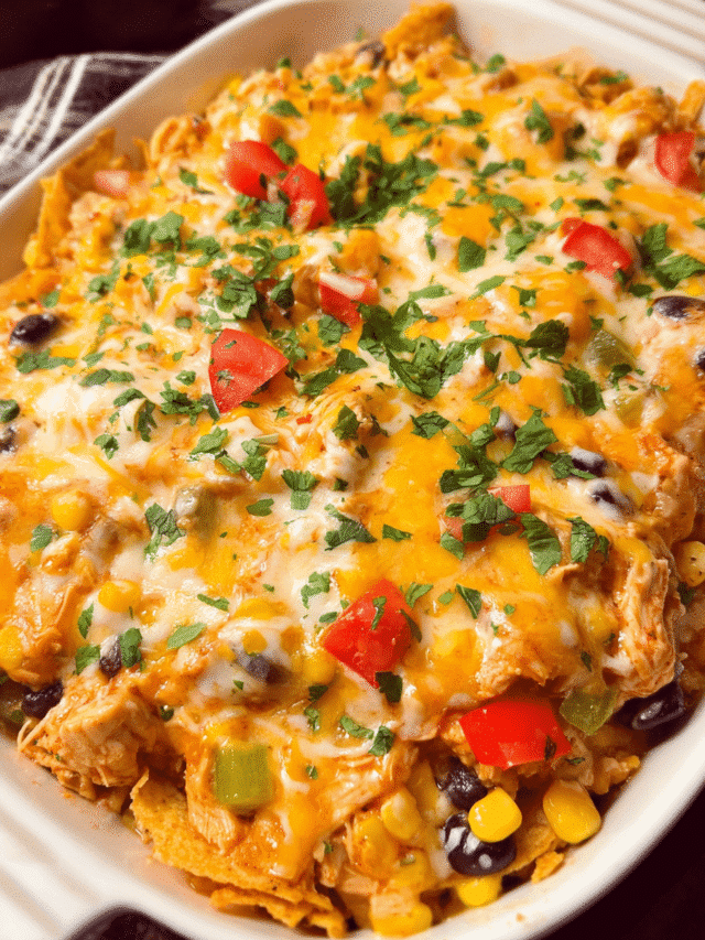 Cheesy chicken taco casserole baked with melted cheese and crushed tortilla chips in a white casserole dish