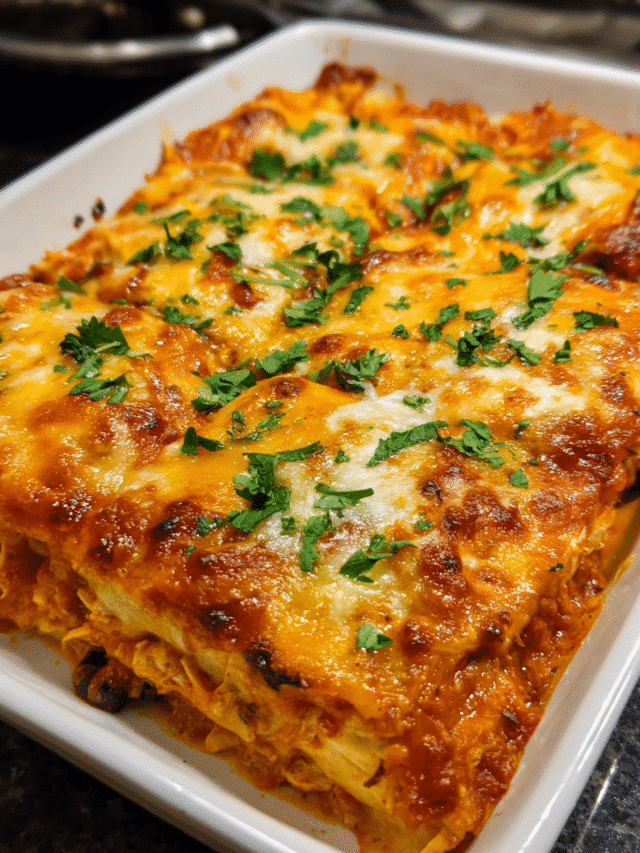 Cheesy chicken enchilada casserole in a baking dish topped with melted Colby Jack cheese.