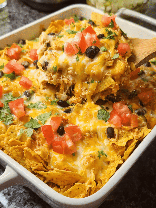 Chicken Nacho Casserole topped with cheese, tomatoes, and jalapeños