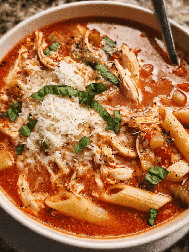 Bowl of Chicken Parmesan Soup topped with basil and melted cheese