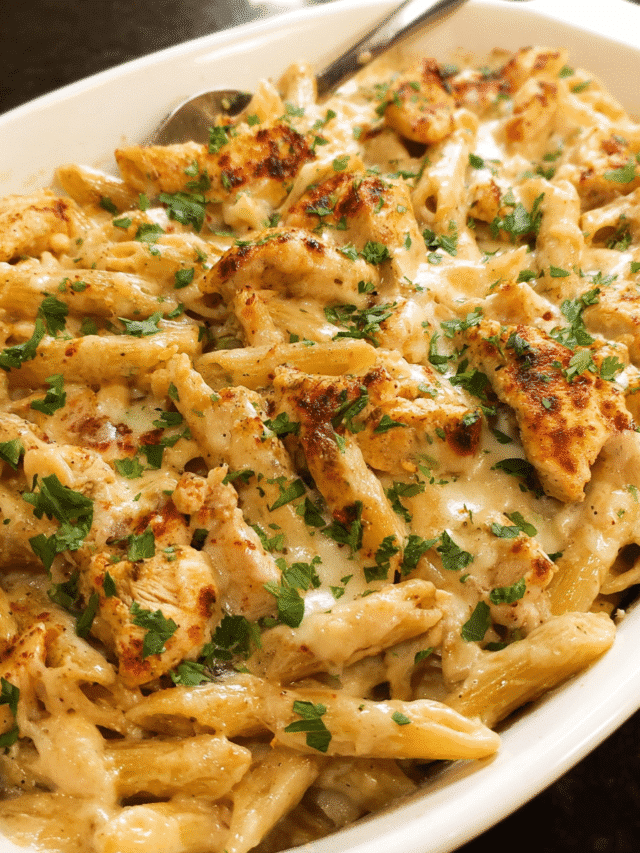 Creamy Cajun Chicken Pasta Bake fresh out of the oven in a white baking dish, bubbling with melted cheese and garnished with parsley.