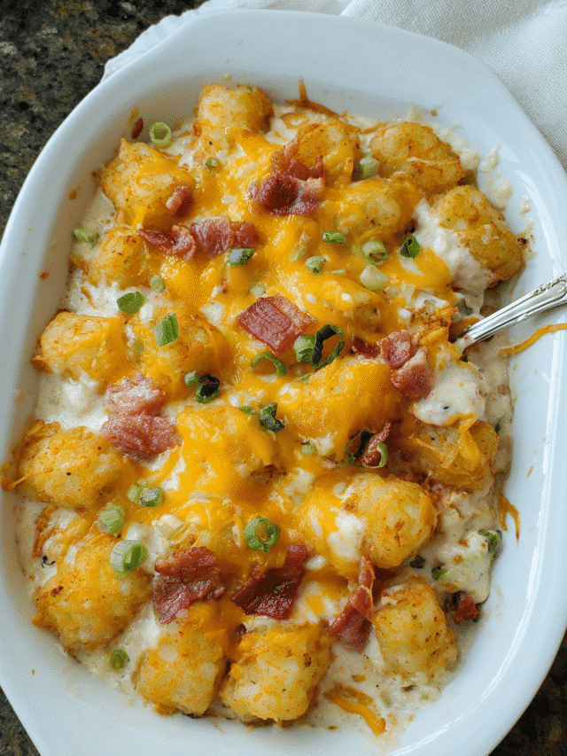 Creamy Chicken Bacon Tater Tot Casserole in a baking dish topped with melted cheese and green onions