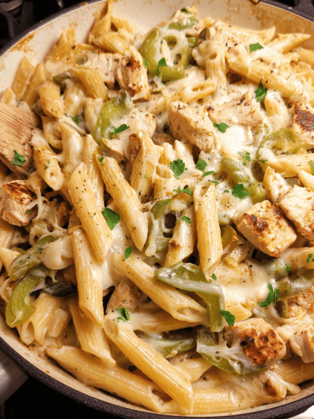 Creamy Chicken Philly Pasta Bake in a skillet with melted provolone