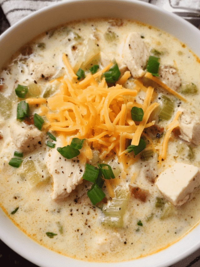A bowl of creamy chicken ranch soup with cheddar and green onions