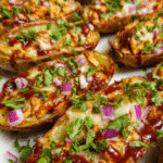 Crispy BBQ Chicken Potato Skins topped with melted mozzarella, diced chicken, red onion, and fresh cilantro