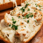 Chicken Alfredo French Bread Pizza sliced with melted mozzarella and parsley garnish