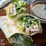 Chicken Caesar Wrap sliced in half with romaine and Parmesan