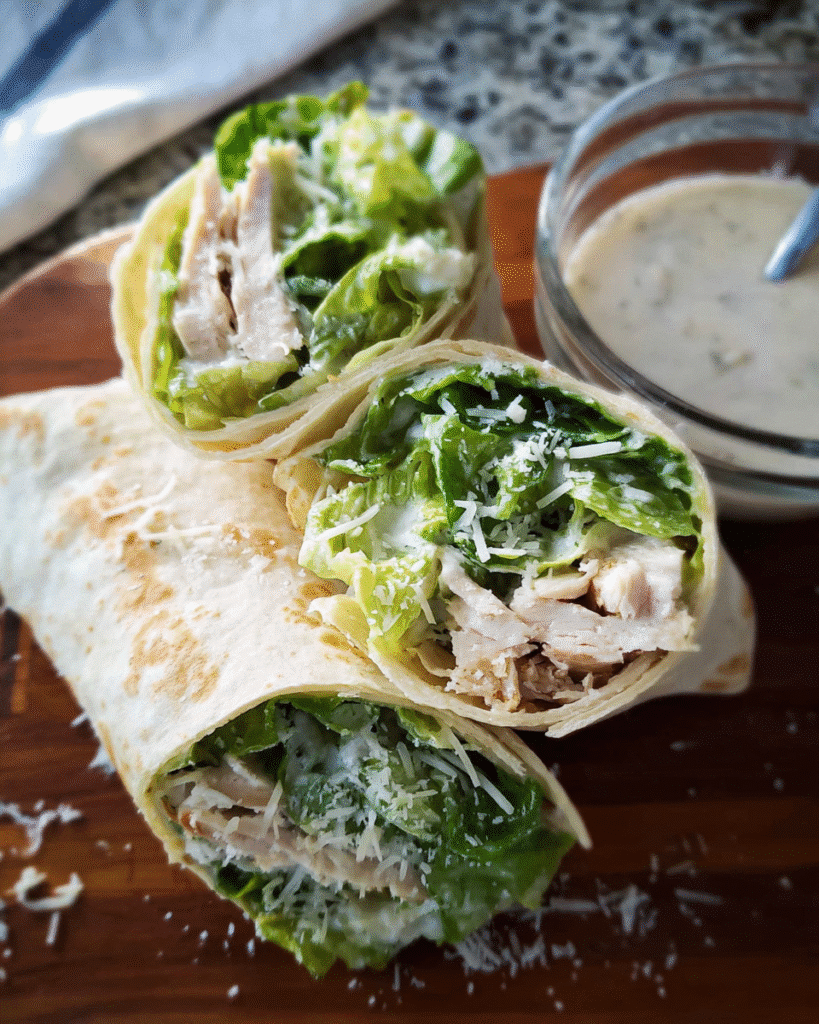 Chicken Caesar Wrap sliced in half with romaine and Parmesan