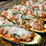 Baked chicken parmesan zucchini boats topped with melted mozzarella and fresh basil