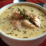Chicken and roasted garlic cream soup in bowl with herbs