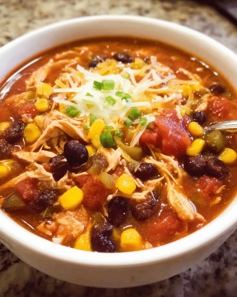 Slow cooker chicken taco chowder in a bowl with toppings