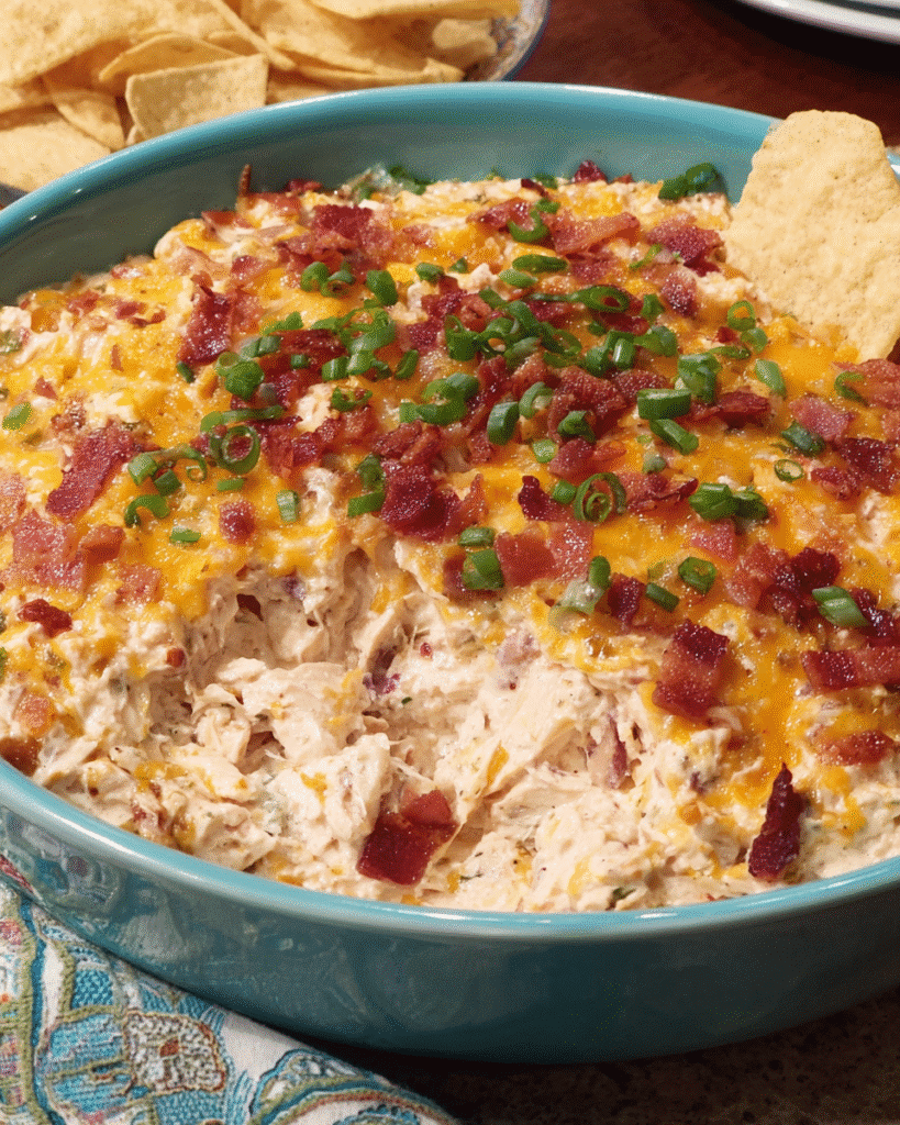 Hot creamy chicken ranch dip with bacon and cheese in a white baking dish