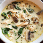 Creamy chicken and spinach soup in a white bowl