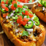 Taco Stuffed Bread sliced on a platter with melted cheese and seasoned beef filling