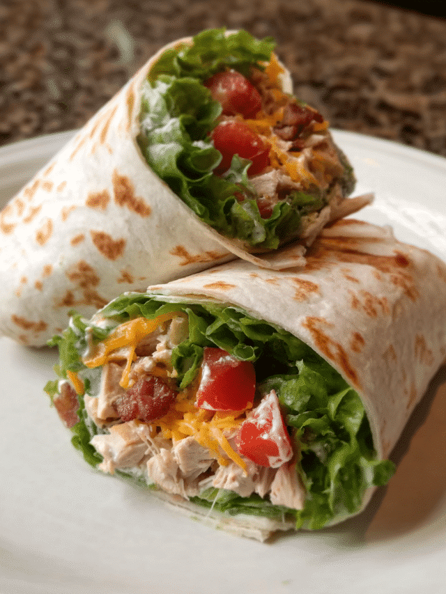 Chicken Bacon Ranch Wrap sliced in half with visible chicken, turkey bacon, cheddar, lettuce, and ranch