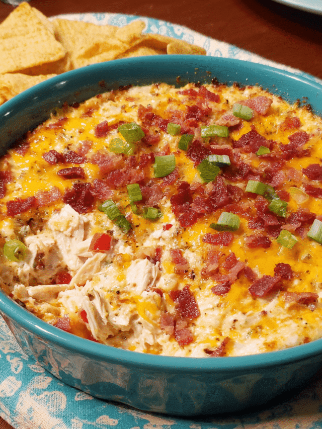 Hot creamy chicken ranch dip with bacon and cheese in a white baking dish