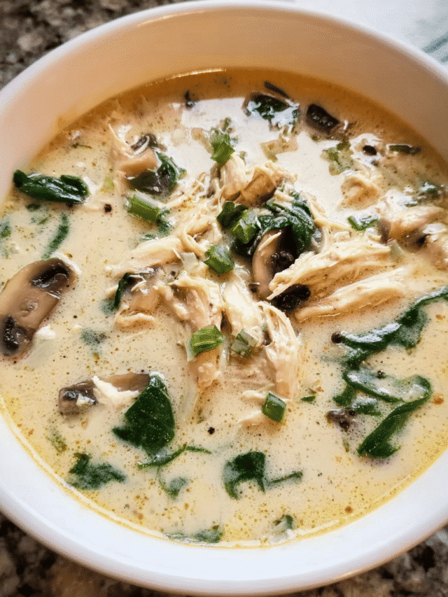 Creamy chicken and spinach soup in a white bowl