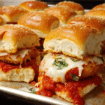 cheesy baked chicken parm sliders in casserole dish