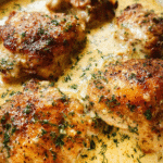 Creamy baked chicken thighs in skillet with garlic sauce