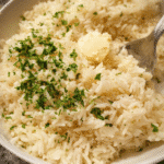 Creamy garlic rice served warm with parsley garnish