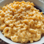 creamy mac and cheese stovetop in a bowl with melted cheddar