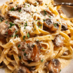 Creamy mushroom pasta in a bowl topped with parmesan and parsley
