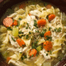 A warm bowl of homemade chicken noodle soup with carrots and herbs