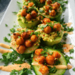 Avocado cucumber bites topped with roasted chickpeas and fresh herbs