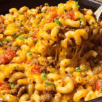 Cheesy baked cheeseburger casserole with macaroni and ground beef in a skillet