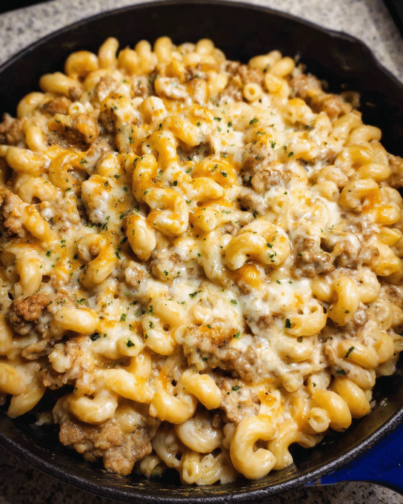 Creamy baked sausage mac casserole served fresh with melted cheese