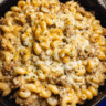 Creamy baked sausage mac casserole served fresh with melted cheese