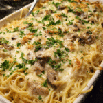 Creamy baked turkey tetrazzini casserole served warm with Parmesan cheese