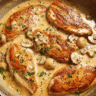 Creamy cheesy garlic chicken bake served in a skillet with parsley garnish