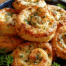 Freshly baked cheesy garlic pinwheels on a serving platter
