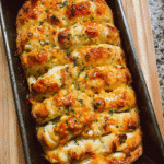 Fresh cheesy garlic pull apart bread in a loaf pan