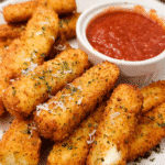 Homemade crispy mozzarella sticks served with marinara sauce