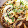 Slow cooker French onion beef served over mashed potatoes with melted Swiss cheese