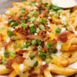 Loaded cheese fries topped with melted cheddar, mozzarella, turkey bacon, and green onions